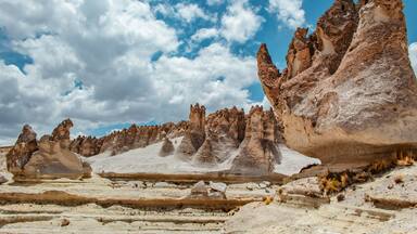 A desert landscape with unique rock formations and a clear blue sky.