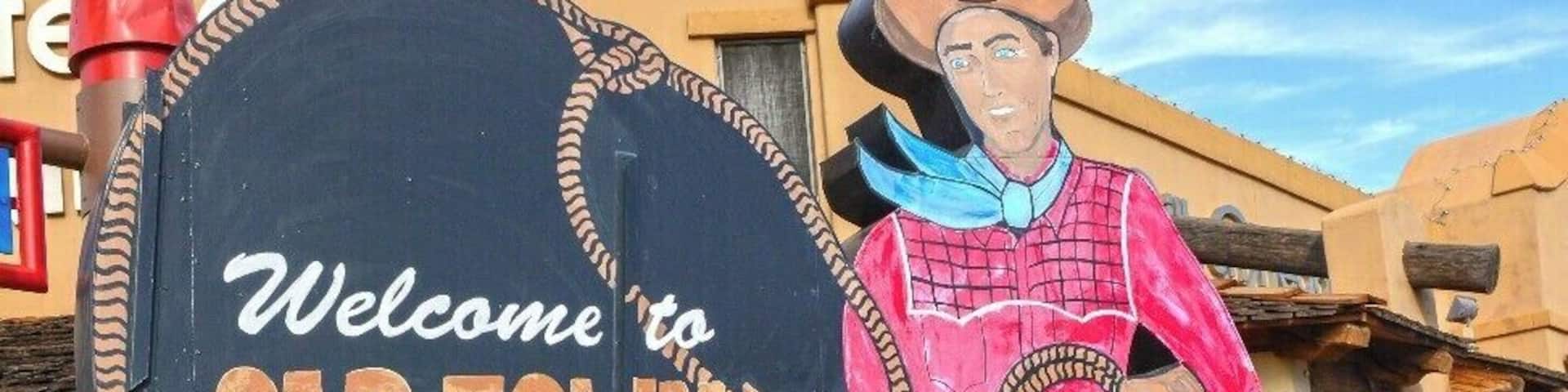 A cowboy statue holding a sign that reads "Welcome to Old Town Scottsdale."