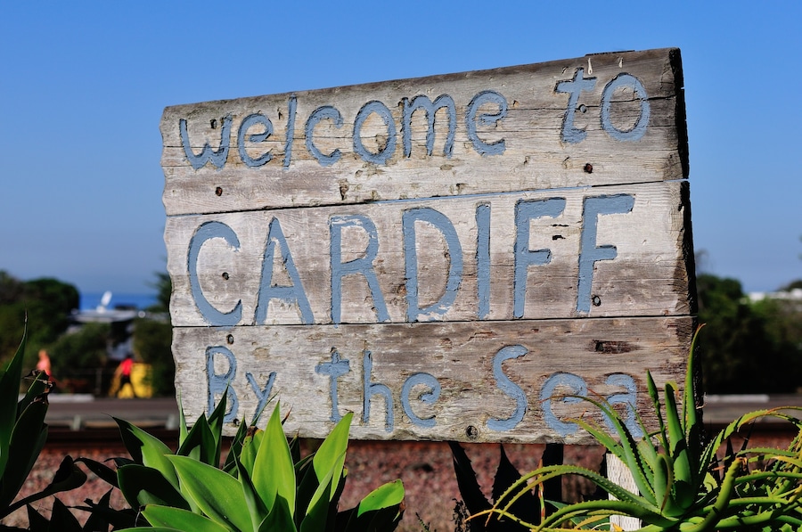 A wooden sign with 'Welcome to CARDIFF By the Sea' written on it.