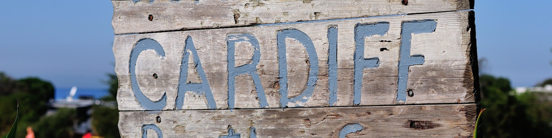 Un letrero de madera con la inscripción 'Welcome to CARDIFF By the Sea'.