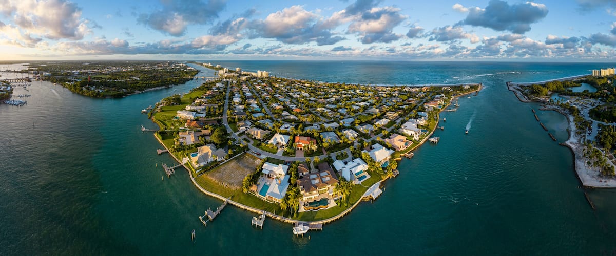 Aerial panoramic view of luxury coastal homes on a peninsula along the ocean inlet in Jupiter, Florida, USA. December 29, 2022.