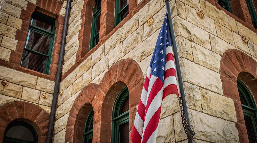 Close Up of American Flag In Front of Stone and Brick Courthouse Building in Stephenville, Texas