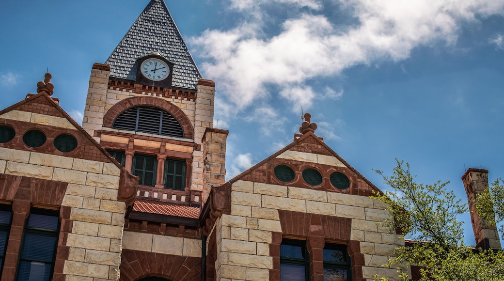 Close Up of Stone and Brick Courthouse Building With Clock Tower and Cloudy Blue Sky in Stephenville, Texas