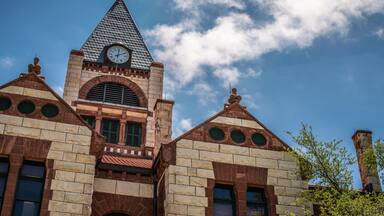 Close Up of Stone and Brick Courthouse Building With Clock Tower and Cloudy Blue Sky in Stephenville, Texas
