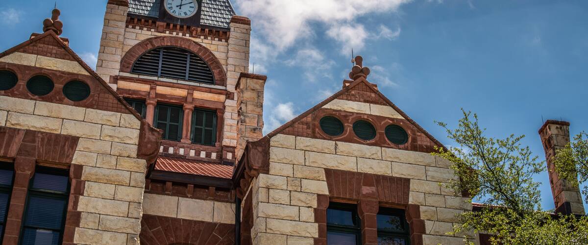 A historic building with a clock tower, arched windows, and a brick facade.
