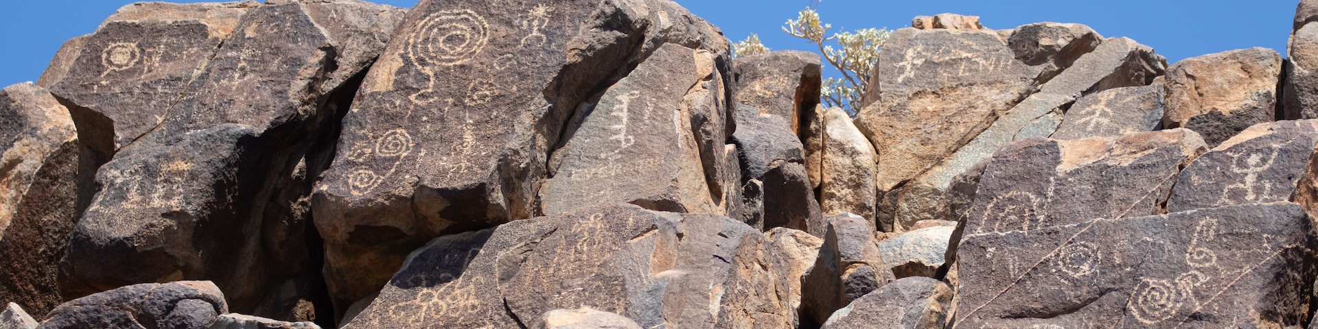 A rocky landscape with large boulders and ancient petroglyphs.