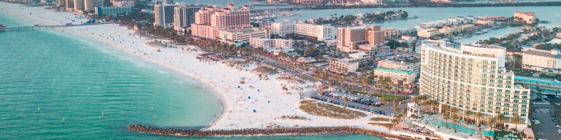 Panorama of city Clearwater Beach FL. Summer vacations in Florida. Beautiful View on Hotels and Resorts on Island. Blue color of Ocean water. American Coast or shore Gulf of Mexico. Sky after Sunset.