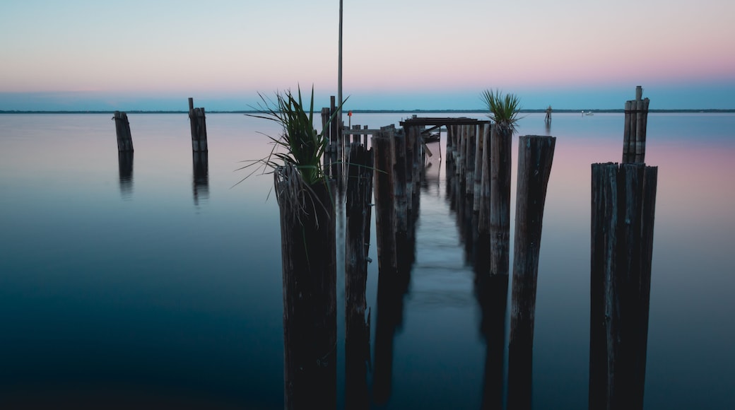 Old historic dock posts in Lake Monroe at downtown Sanford Riverwalk in Florida at sunset
