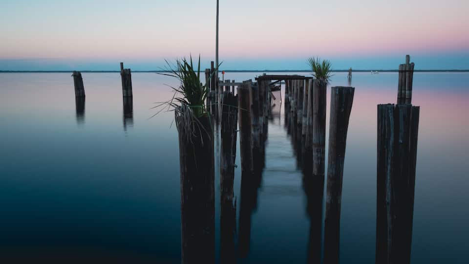 A tranquil waterfront with wooden piers and a clear sky.