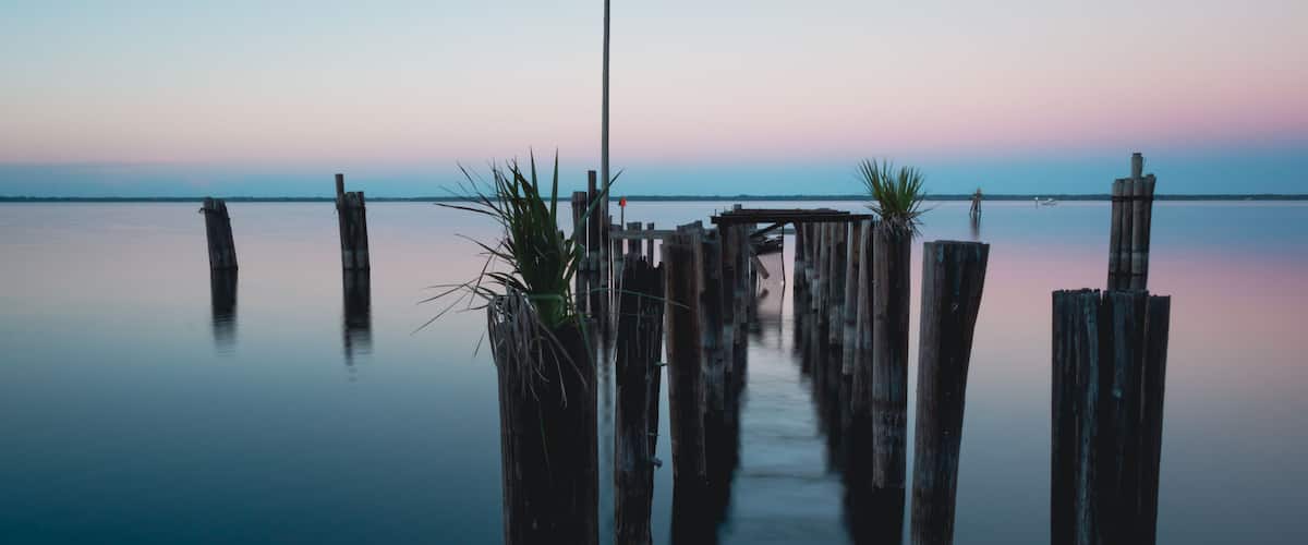 A tranquil waterfront with wooden piers and a clear sky.