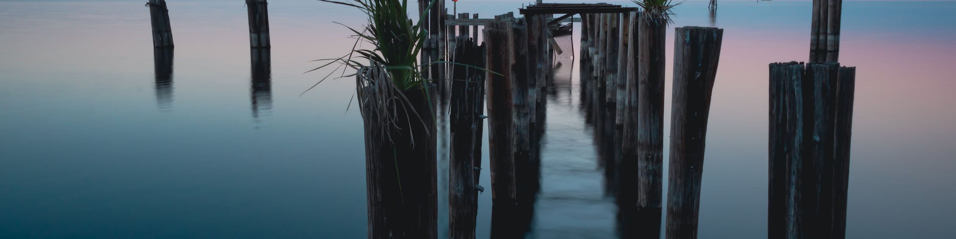 A tranquil waterfront with wooden piers and a clear sky.