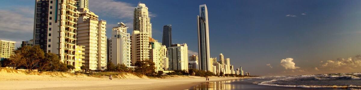 A coastal cityscape with high-rise buildings along a sandy beach.