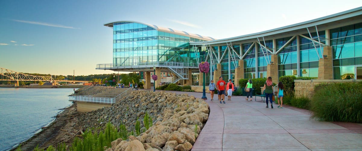 A modern glass building with a bridge in the background.