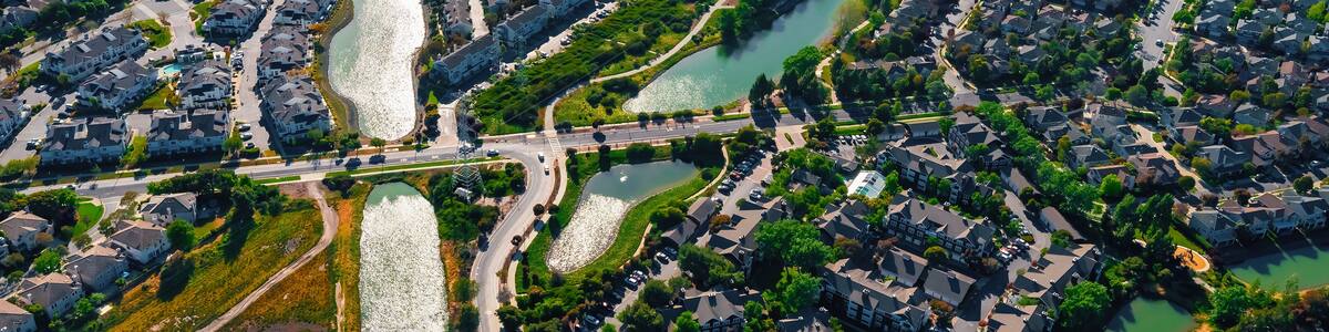Eine Luftaufnahme eines Wohngebiets mit Häusern, Straßen und einem Fluss.