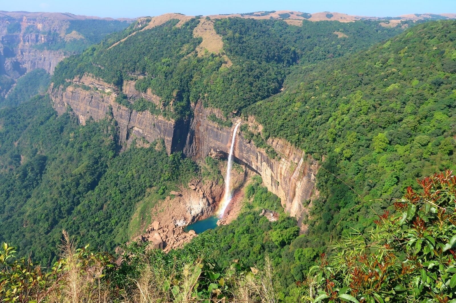 Cañón con cascada y vegetación exuberante.