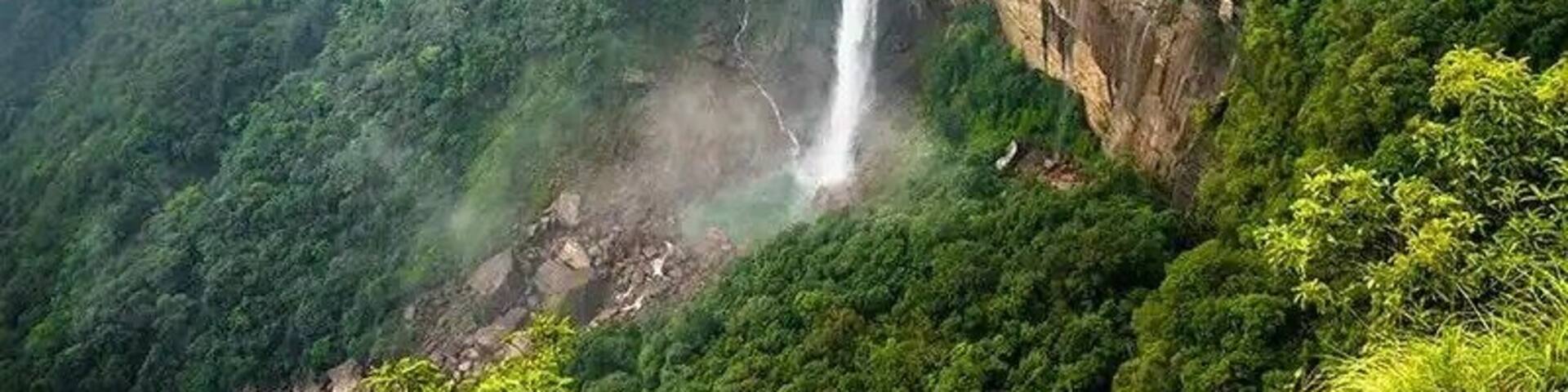 A waterfall cascading down a lush, green mountain.