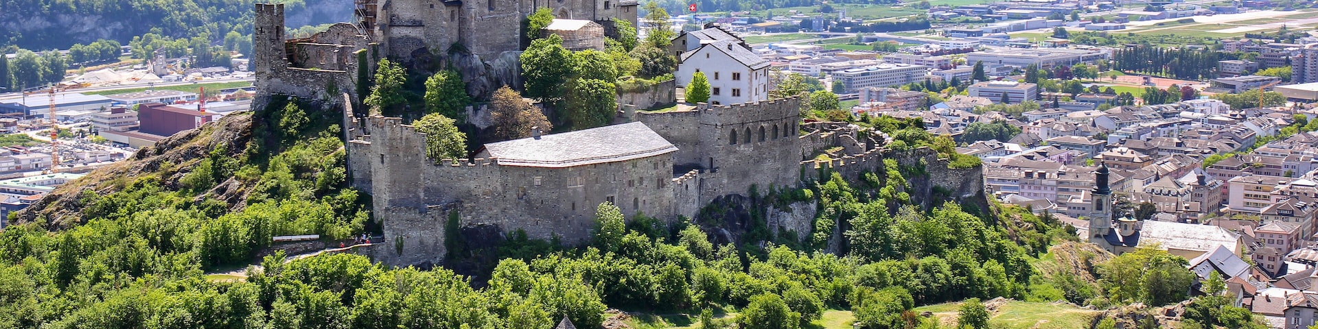 A historic castle on a hill overlooking a town.