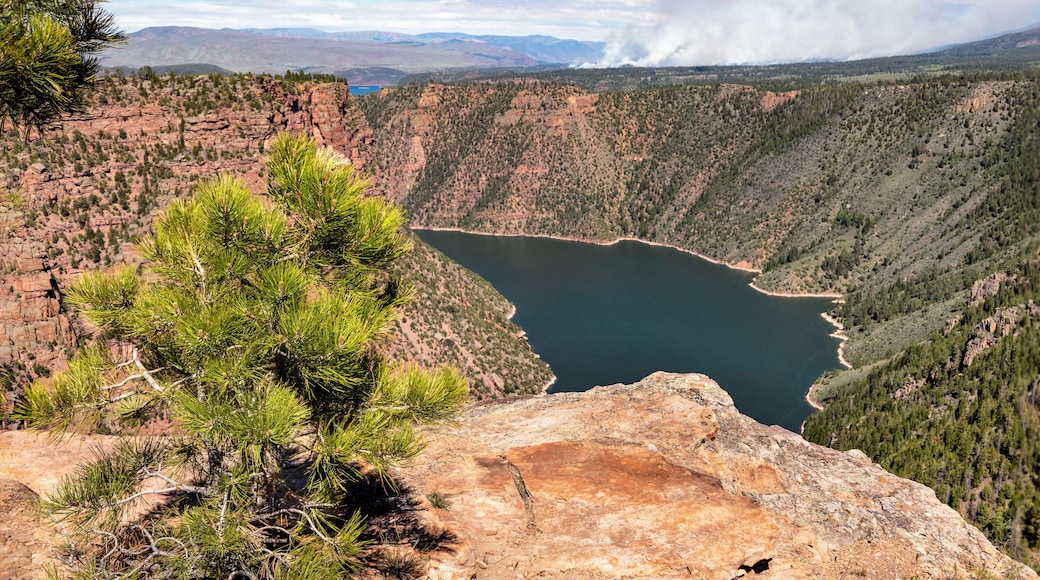 We passed this spot near Flaming Gorge as we drove from Jackson WY to Vernal Utah as part of a road trip. In the distance a forest fire can be seen. It turned out to be part of a controlled burn. This area is beautiful but care is needed as there are a lot of drop offs and deep cracks in the cliffs to get over.