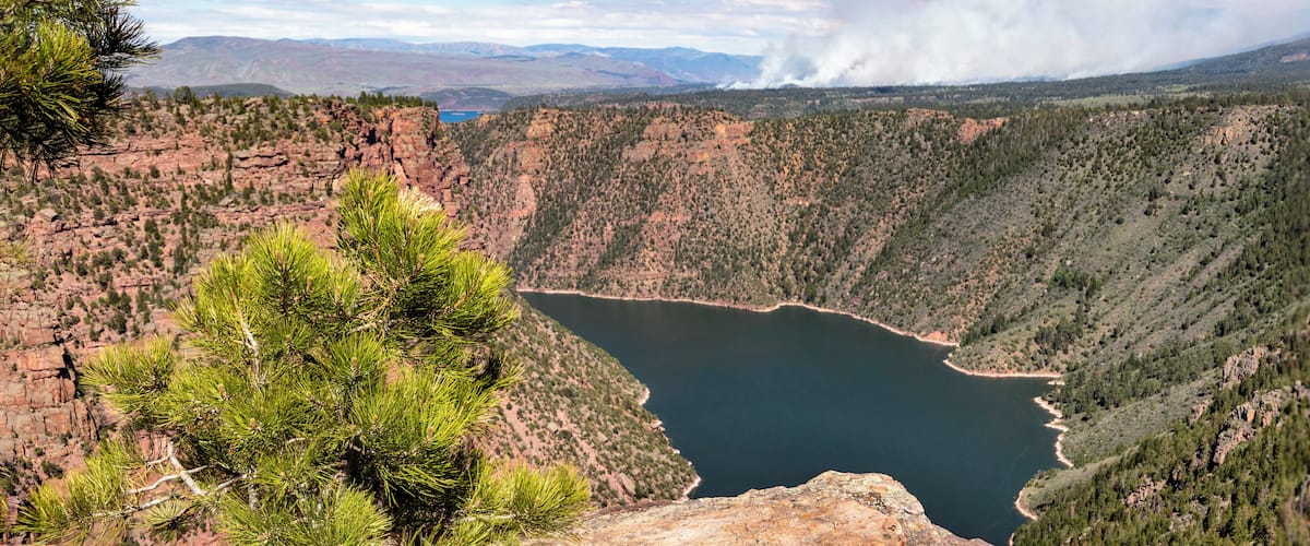 A canyon with a lake, surrounded by rocky terrain and sparse vegetation.