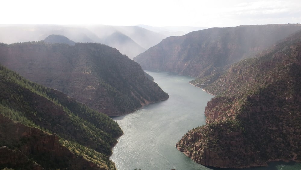 A river winding through a canyon with steep, forested hills.