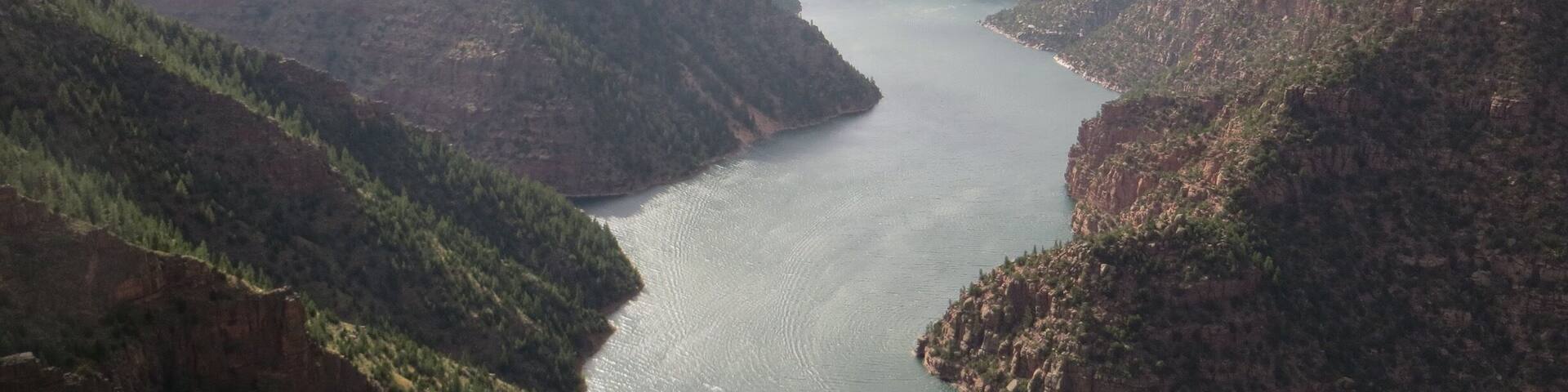 A river winding through a canyon with steep, forested hills.