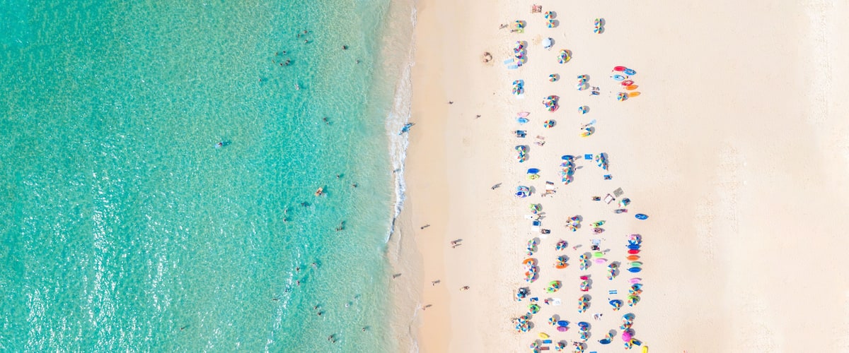 A beach with clear turquoise water and a sandy shore.