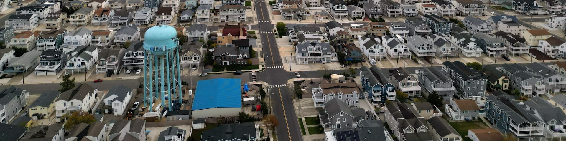 A coastal residential area with a water tower and a beach.