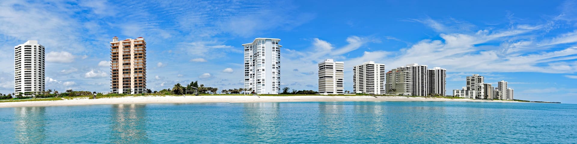 A panorama of Singer Island, Florida from the Atlantic Ocean, with a white sandy beach and upscale condos.
