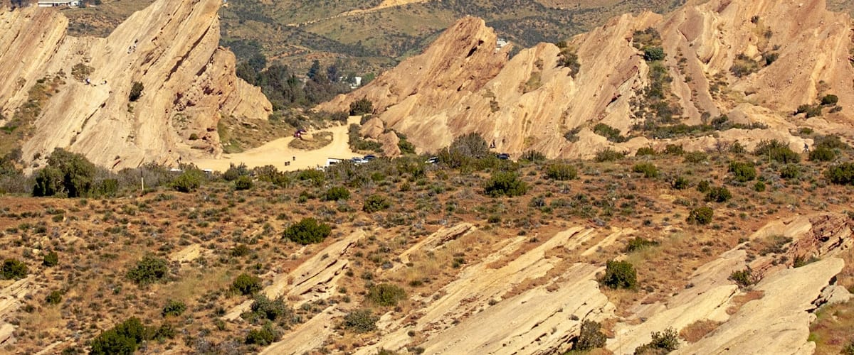 A rugged desert landscape with prominent rock formations and sparse vegetation.
