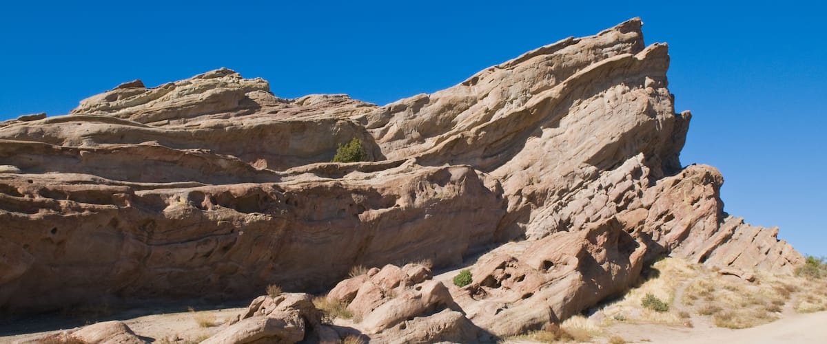 A large rock formation with a clear blue sky.