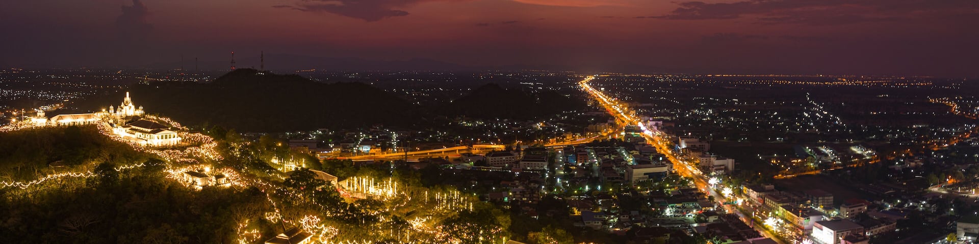 A stunning display of golden fireworks lights up the night sky above an illuminated hilltop palace. The vibrant celebration contrasts beautifully with the dark sky, Phetchaburi festival firework.