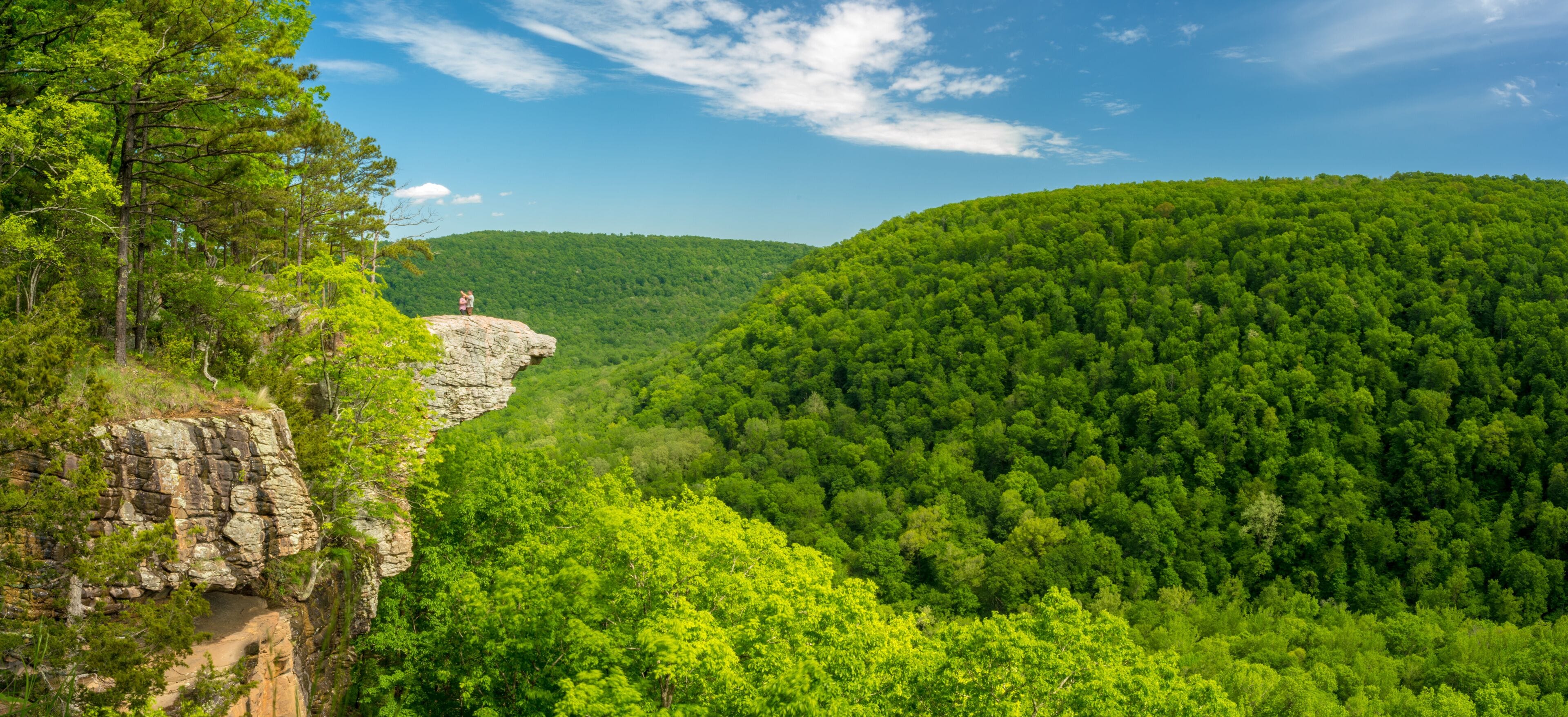 Tourist visitors couple taking pictures at Whitaker Point rock cliff hiking trail, landscape view, Ozark mountains, nwa northwest arkansas