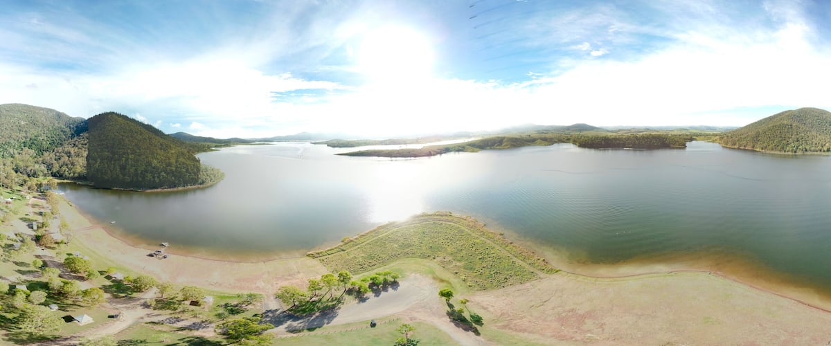 A large lake surrounded by hills and sparse vegetation.