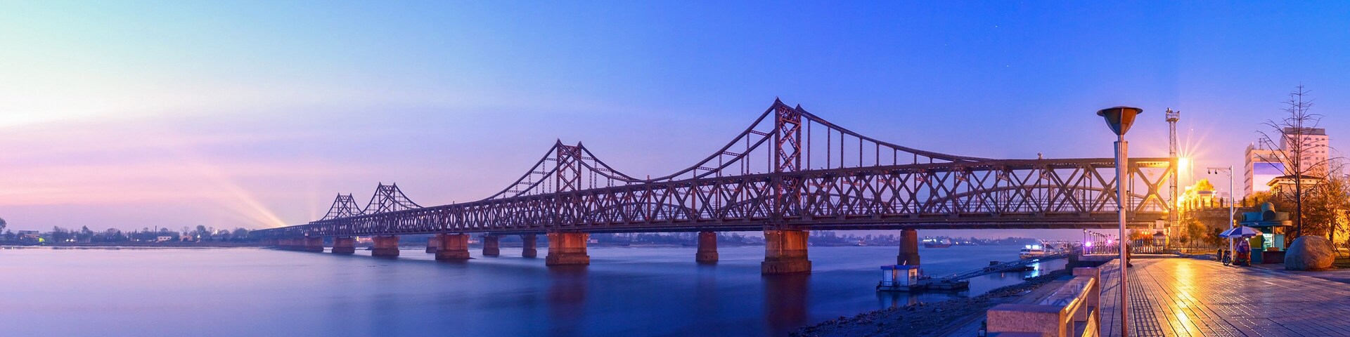 Yalu River Bridge at morning. In the distance is North Korea. Located in Dandong, Liaoning, China.