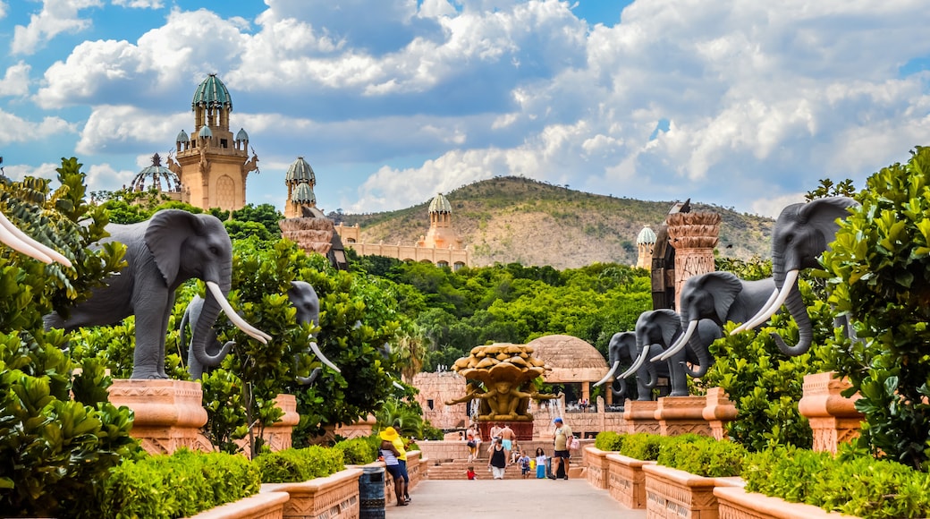 Entrance of The Palace / Lost City /Sun City with stone statues under blue and cloudy sky