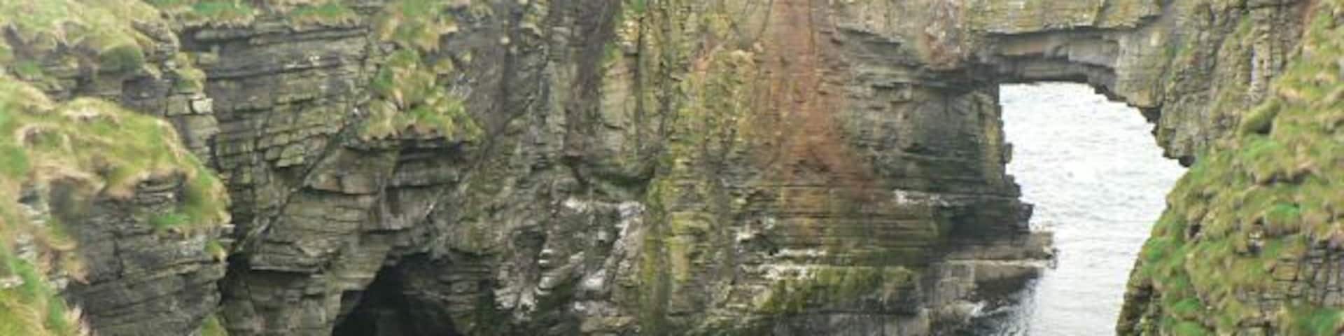 Vat of Kirbuster. The vat is a "gloup" - a partially collapsed sea cave with part of the roof remaining and forming an arch. (The name is sometimes spelt Kirbister. The SNH sign at the nearby car park has both spellings.)