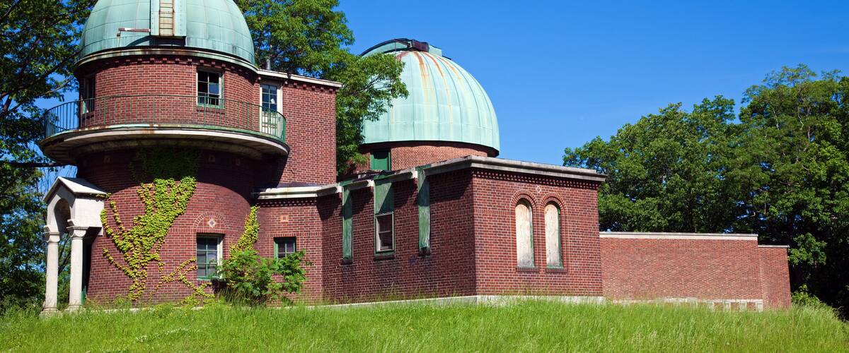 A brick observatory with two domes and a tower.