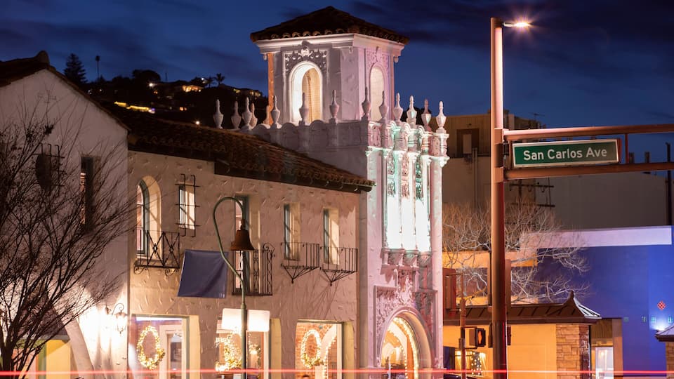 A historic building with ornate architecture and a street sign reading "San Carlos Ave."