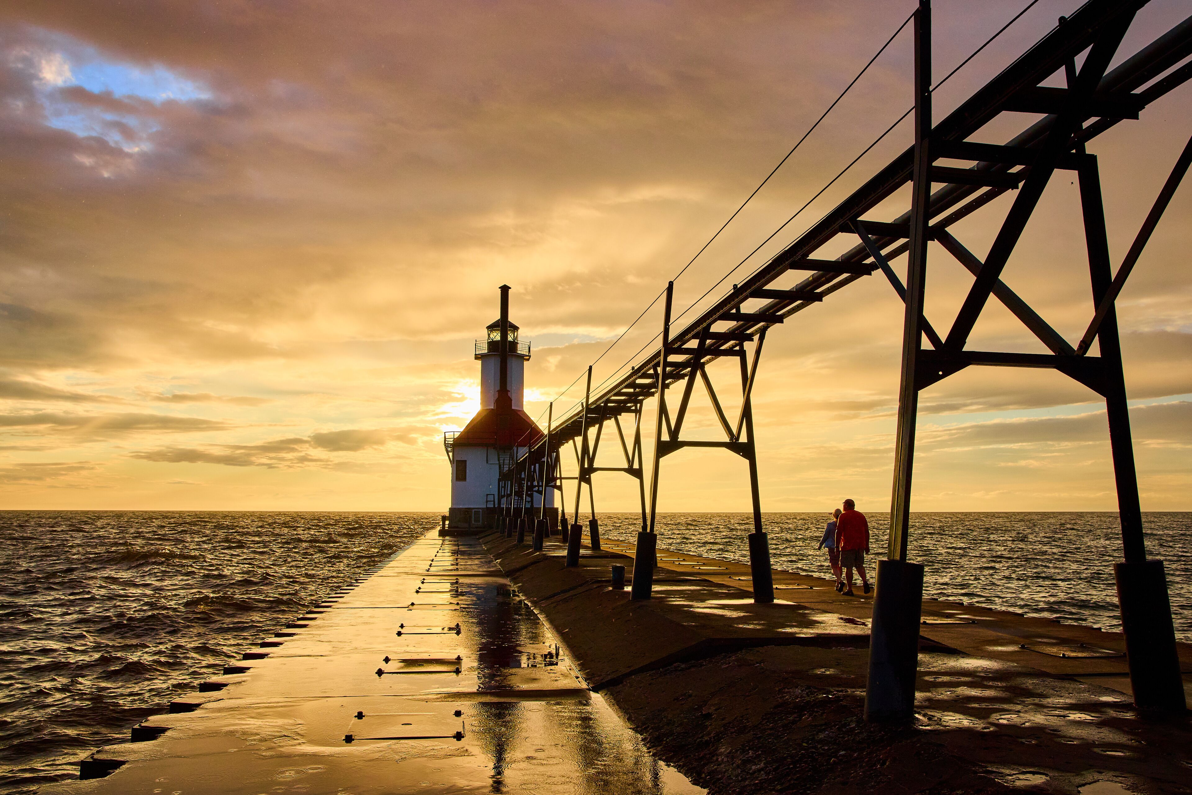 Lighthouse at Sunset with Couple on Pier from Eye-Level Perspective