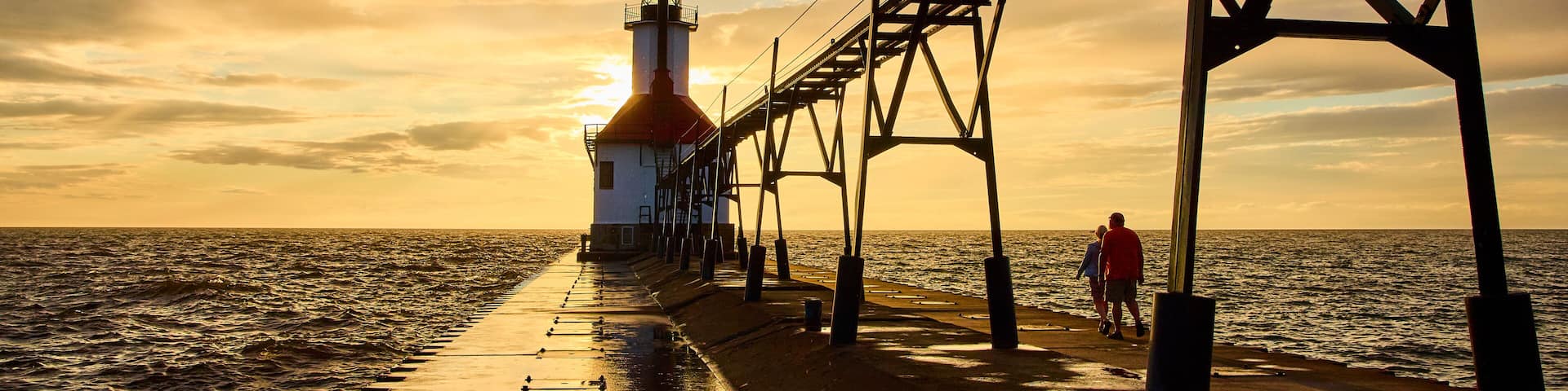 Lighthouse at Sunset with Couple on Pier from Eye-Level Perspective