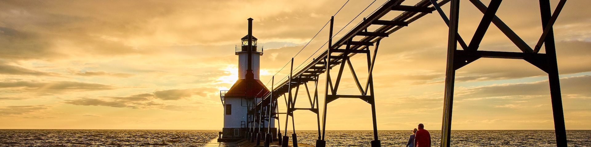 Lighthouse at Sunset with Couple on Pier from Eye-Level Perspective