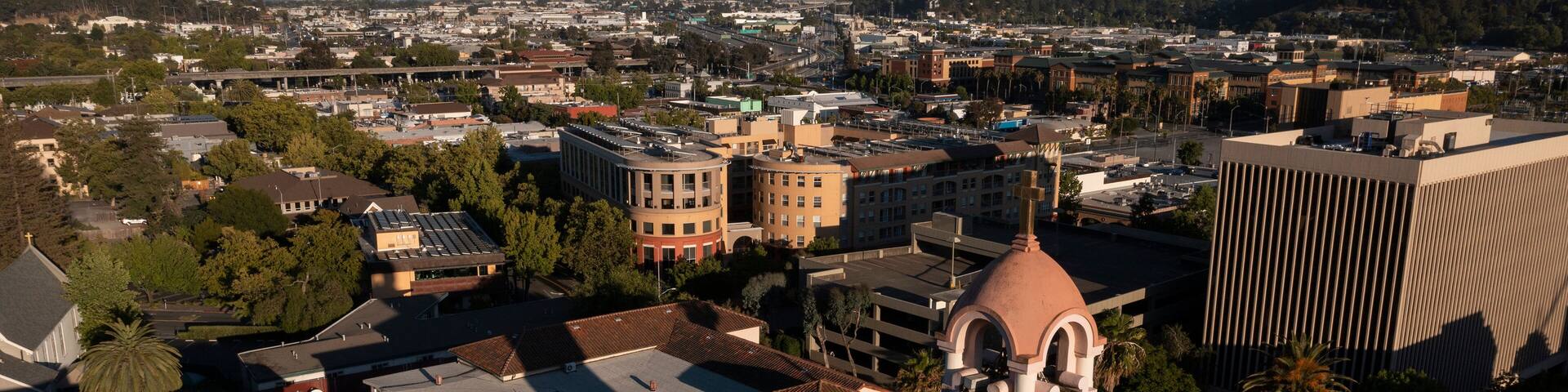 Sunset light shines on the historic Spanish Colonial mission and downtown skyline of San Rafael, California, USA.