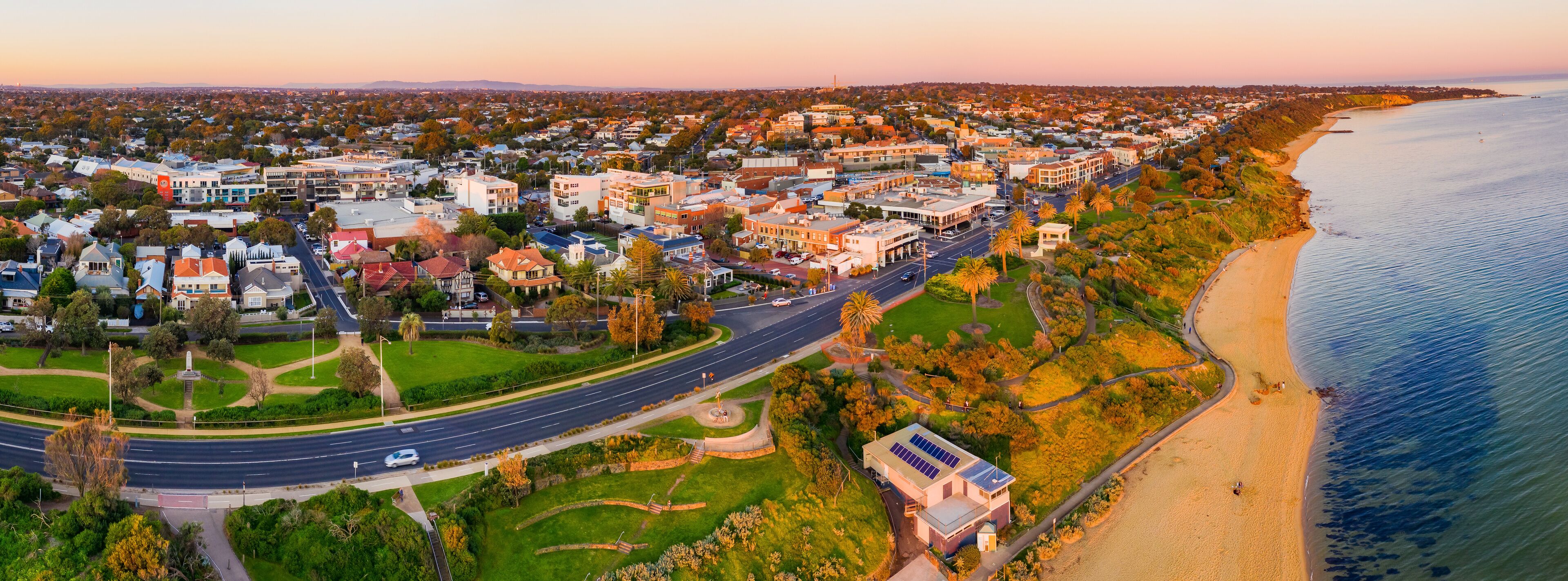 Waterfront property along a batside espalnade in golden lighting