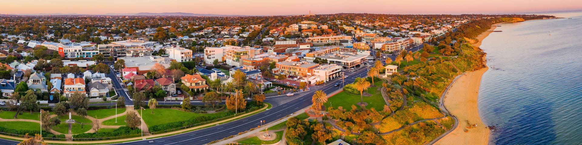 Waterfront property along a batside espalnade in golden lighting