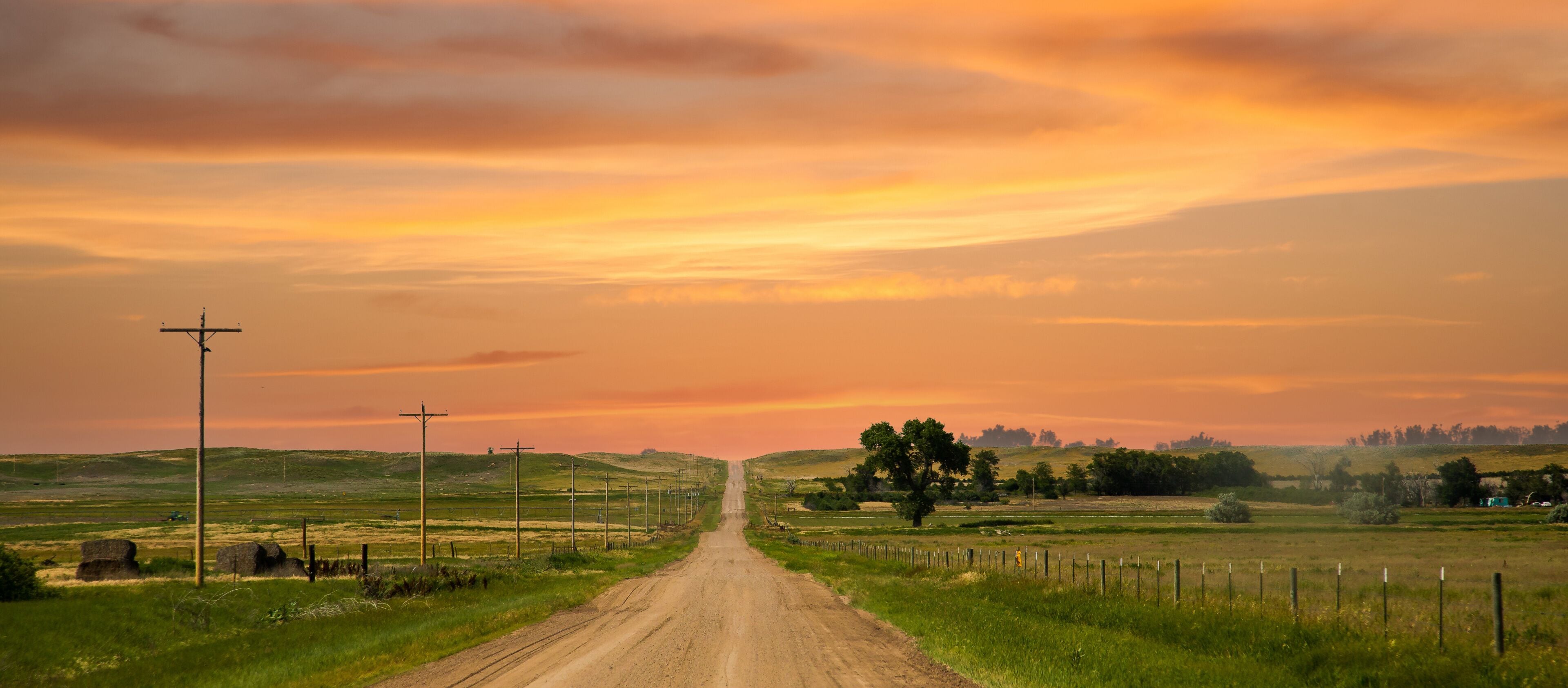 a county gravel road runs through farm land in north eastern Colorado east of Sterling