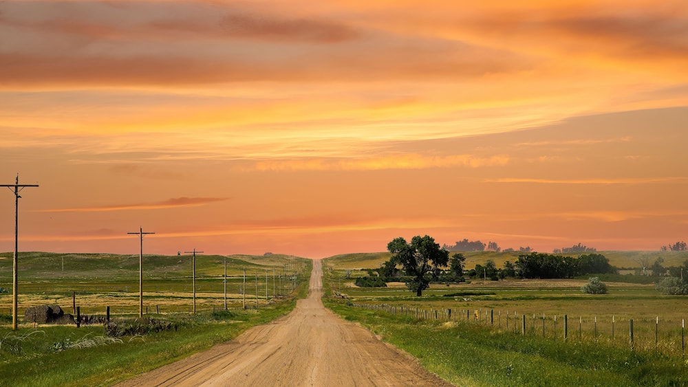 a county gravel road runs through farm land in north eastern Colorado east of Sterling