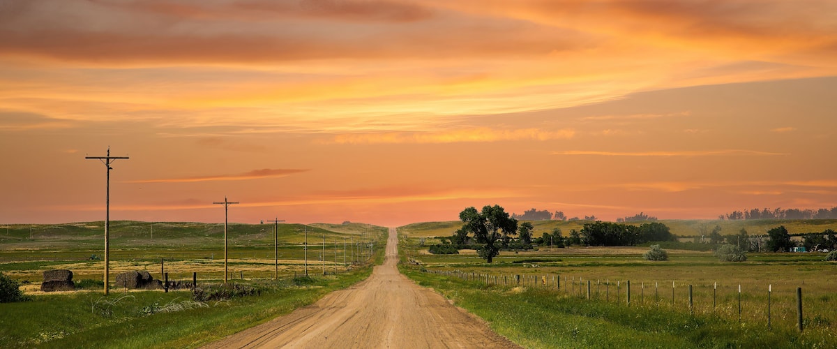 a county gravel road runs through farm land in north eastern Colorado east of Sterling