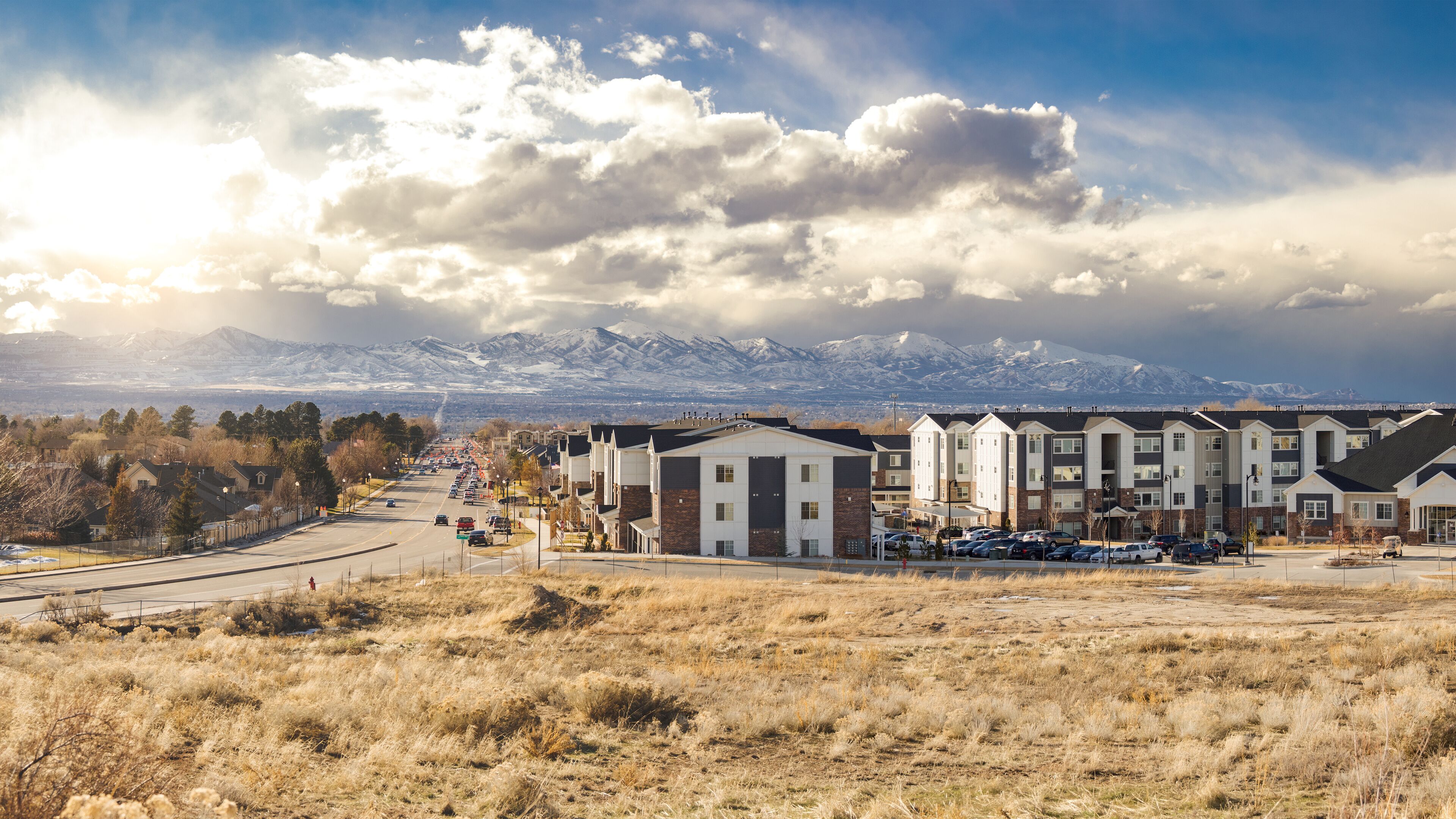 Salt Lake City, Utah Suburb Housing Development, Mountain Background with Overcast Sky next to a Main Road with Traffic