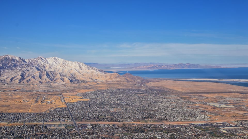 A cityscape with mountains and a body of water in the background.