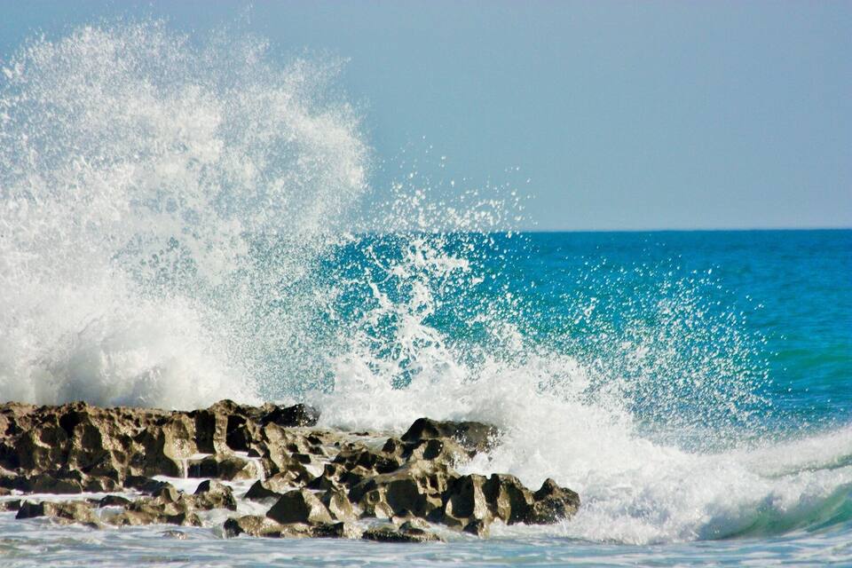 Una costa rocosa con olas rompiendo contra las rocas.